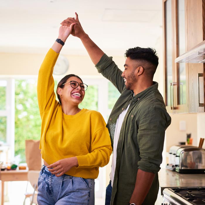 Shot of a young couple dancing together in their kitchen