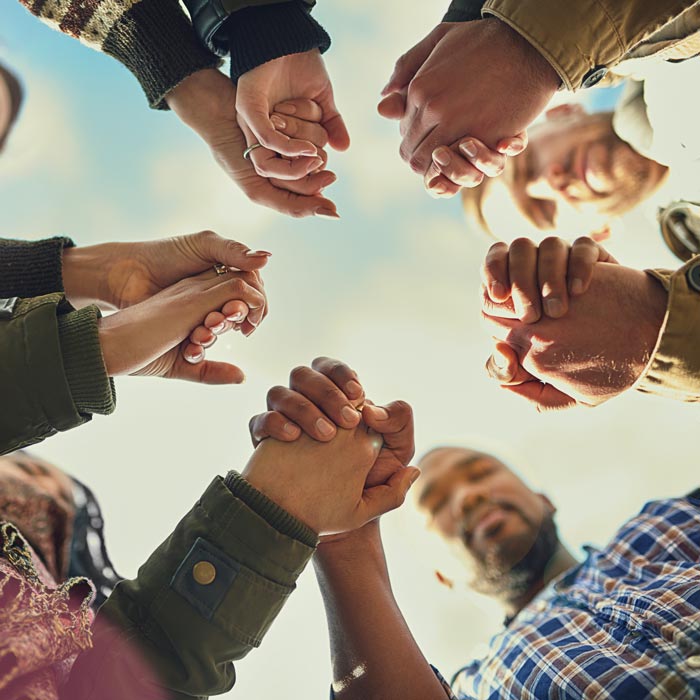 Shot of a group of friends putting their hands together