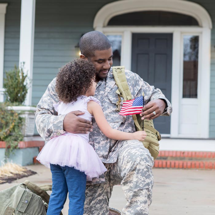 little girl greeting military dad outside home
