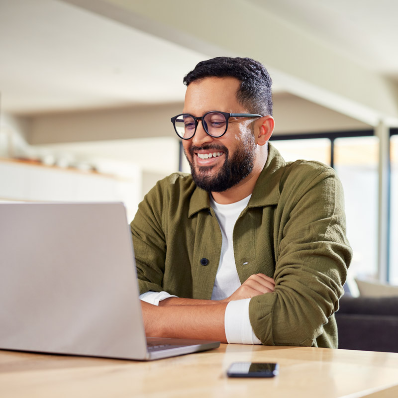 man smiling and looking at laptop